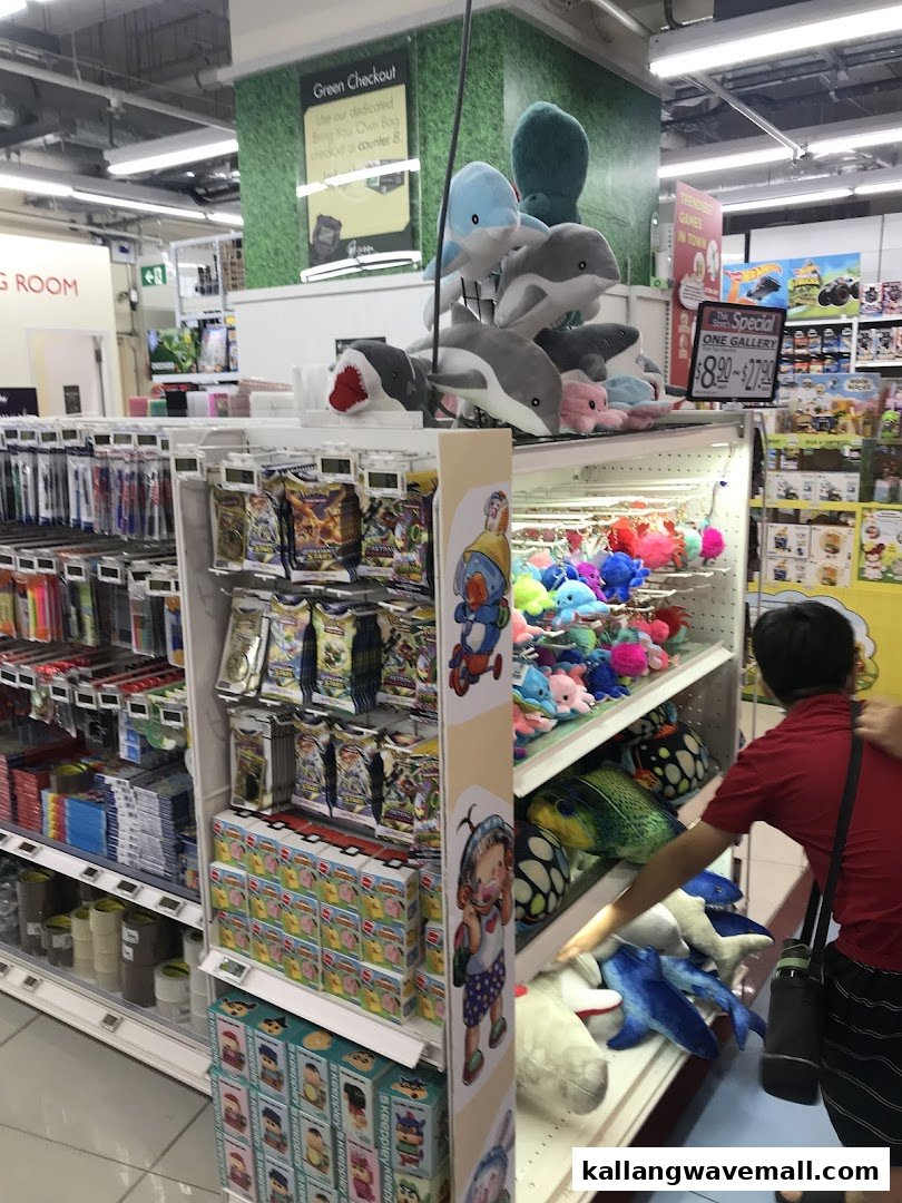 Supermarket aisle with plush toys, games, and stationery, featuring a shopper browsing.