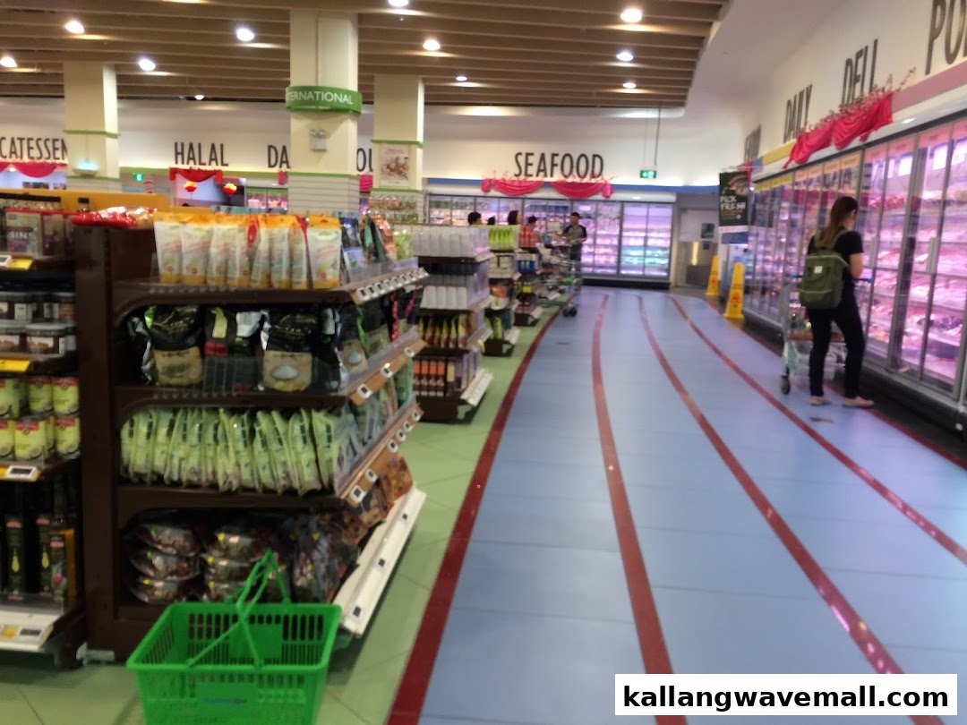Wide aisle of FairPrice Xtra supermarket with track-themed flooring, refrigerated sections, and product shelves.