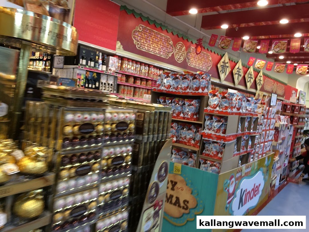 An aisle inside FairPrice Xtra, featuring festive displays of chocolates and various grocery items.