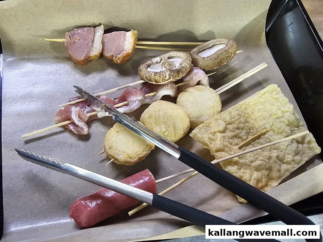 A close-up of various skewered ingredients like meat, mushrooms, and fish balls, ready for hotpot or grilling.