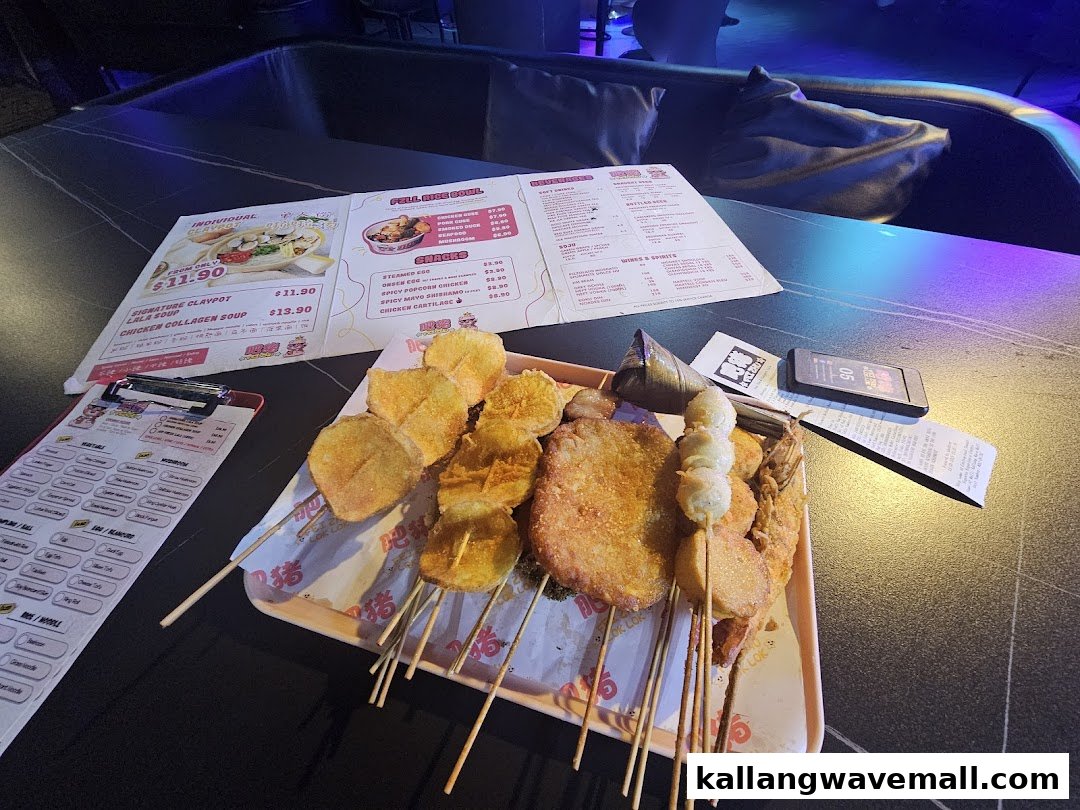 A table laden with various fried skewers, a menu, and an order form in a restaurant setting.