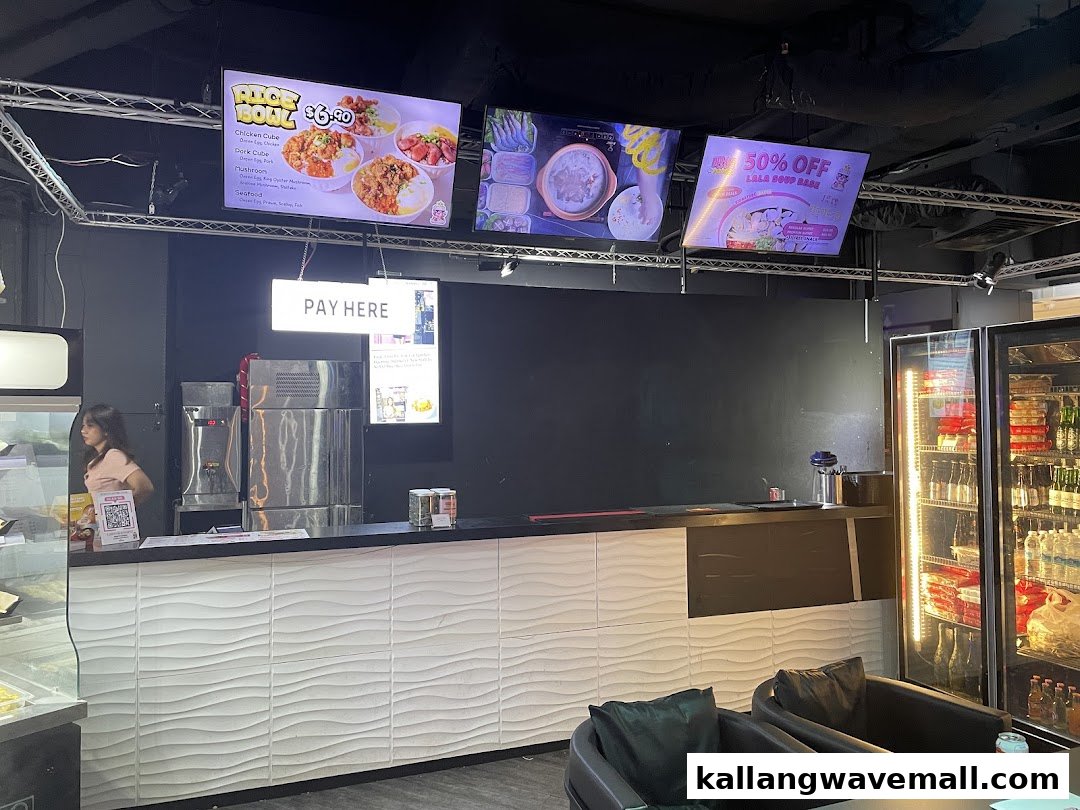 Interior view of Fei Zhu Lok Lok restaurant featuring a service counter, digital menu displays, and a beverage cooler.