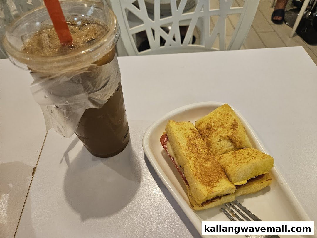 A plate of golden-brown kaya toast and an iced beverage on a white table.