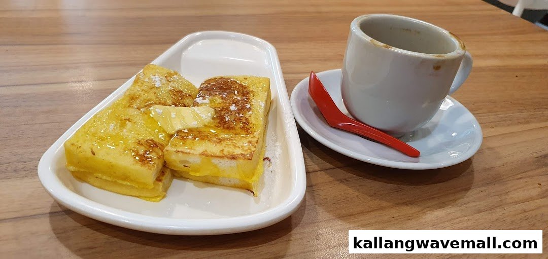 Golden French toast with butter and syrup, served with a cup of coffee on a wooden table.