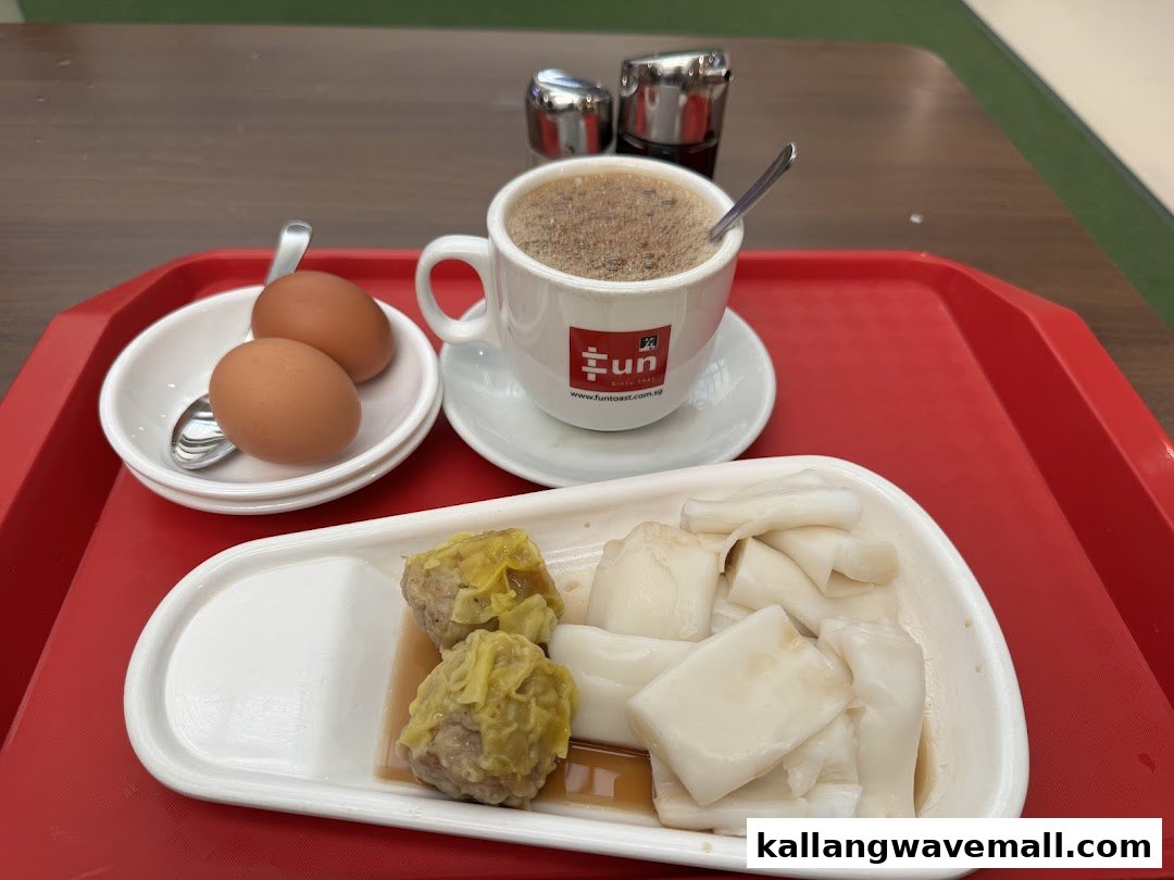 A red tray holds a traditional breakfast set with soft-boiled eggs, hot beverage, siew mai, and chee cheong fun.