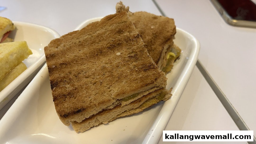 Close-up of two slices of traditional kaya toast served on a white rectangular plate.
