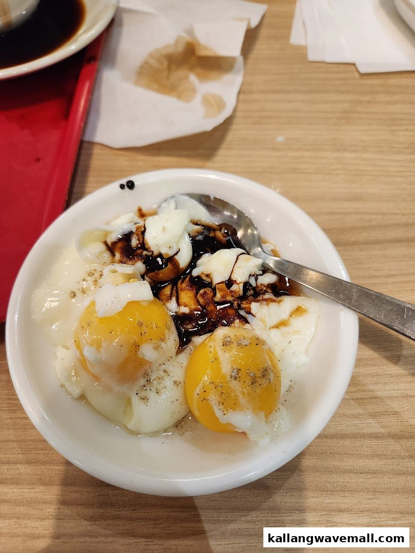 A close-up of two half-boiled eggs with soy sauce and pepper in a white bowl.