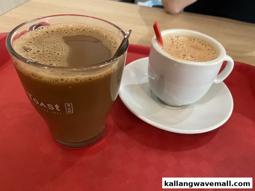 Two frothy beverages, one in a tall glass and one in a small cup, served on a red tray.