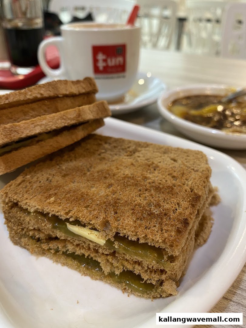 A close-up of traditional kaya toast with butter, a cup of coffee, and soft-boiled eggs from Fun Toast.