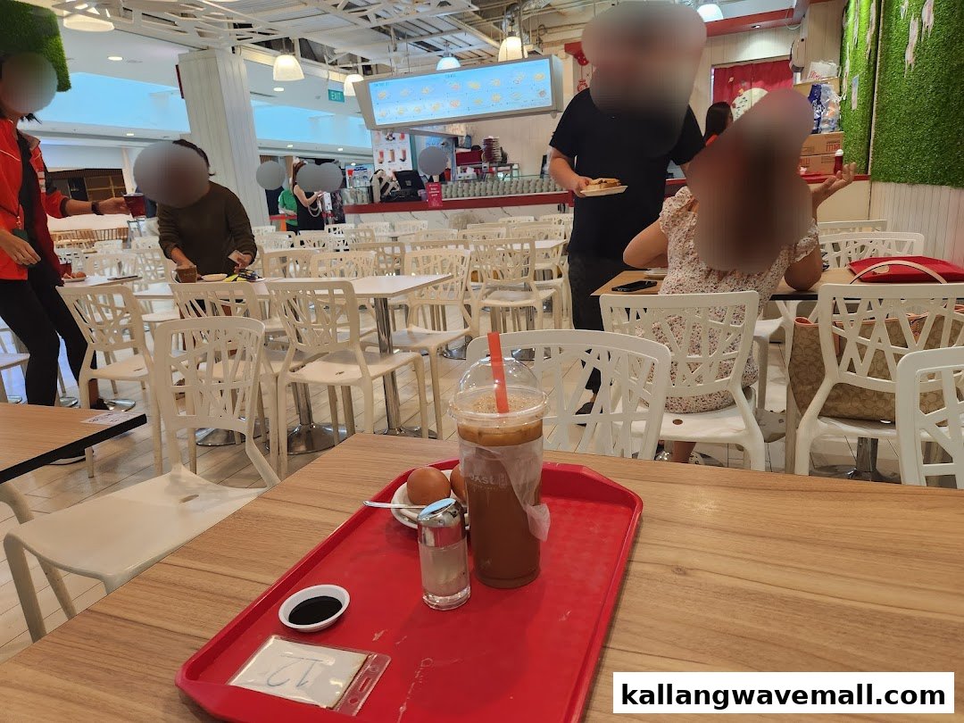 A customer's tray with coffee and eggs on a wooden table in a bustling Fun Toast outlet.