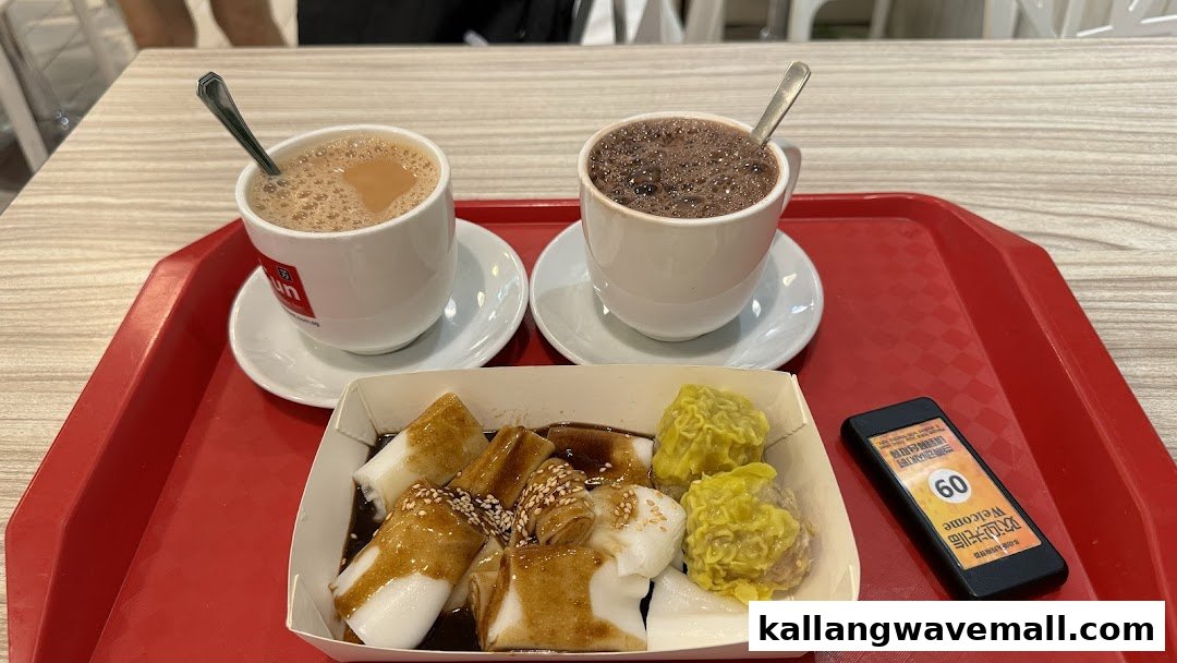 A red tray holds two hot beverages and a box of rice rolls and dim sum.