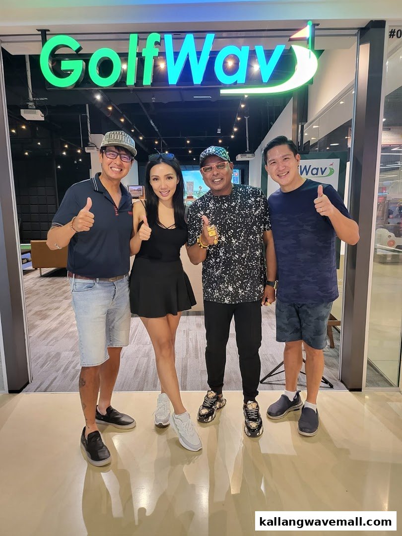 Four people pose with thumbs up in front of the GolfWav shop entrance.