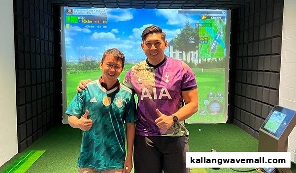 Two men smiling and giving thumbs up in a golf simulator bay.