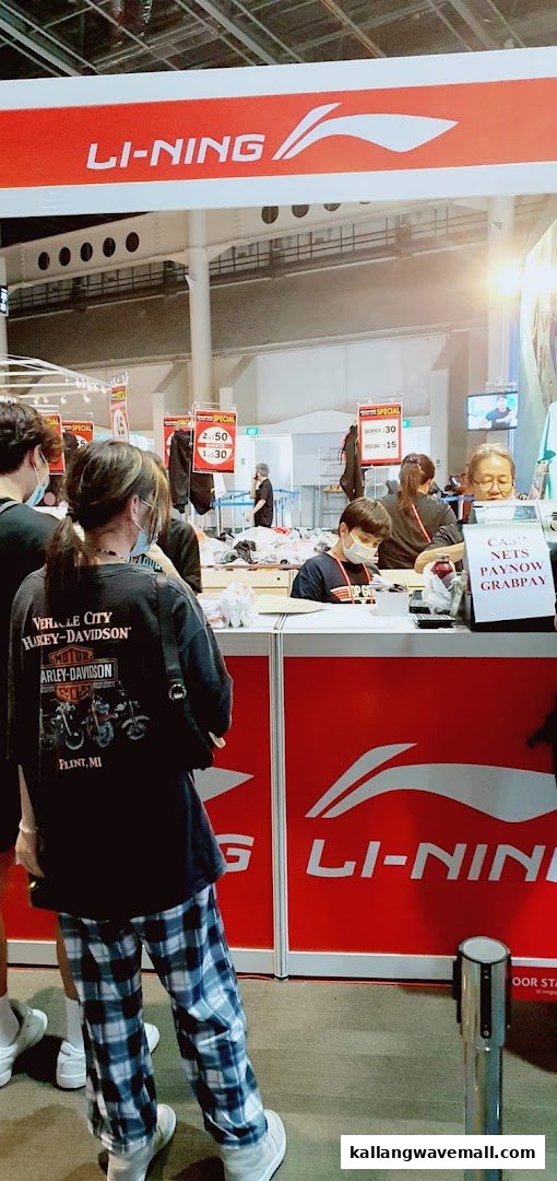 Customers browse and purchase sports apparel at a LI-NING retail booth.