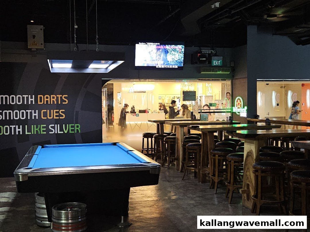 An interior view of Good Cheer Stadium, featuring a pool table, high tables, and a counter area.