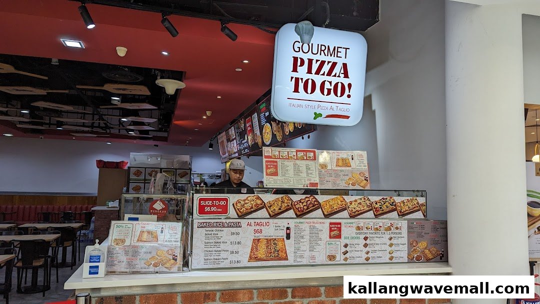 A bustling counter at Gourmet Pizza To Go! featuring Italian-style pizza and baked dishes.