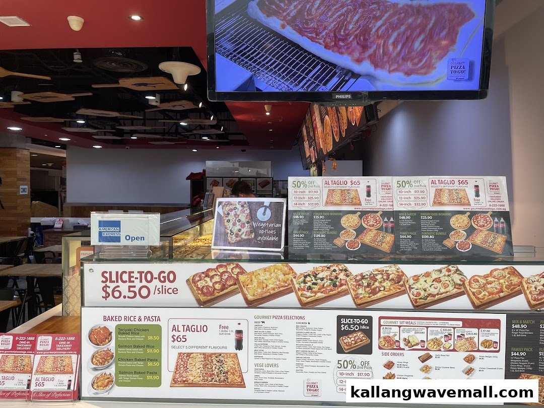 A vibrant display of pizzas, menus, and baked dishes at a 'Gourmet Pizza To Go!' counter.
