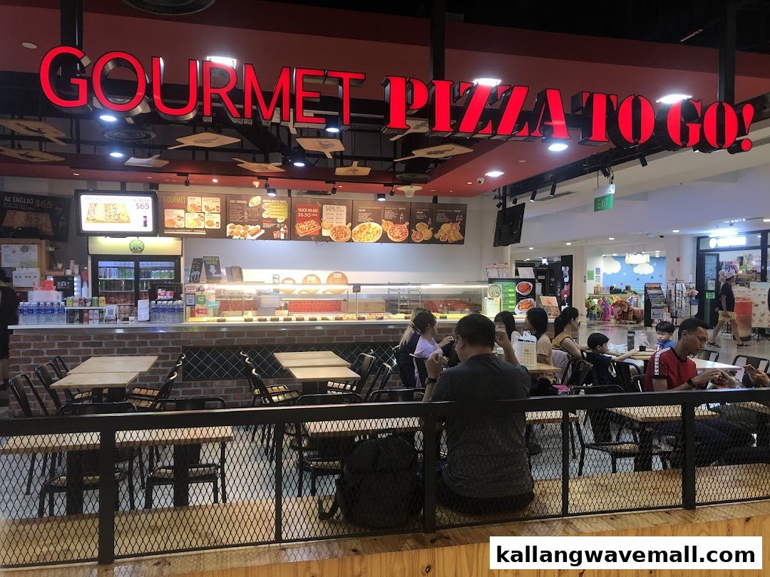 Interior view of Gourmet Pizza To Go! with customers dining and a service counter.