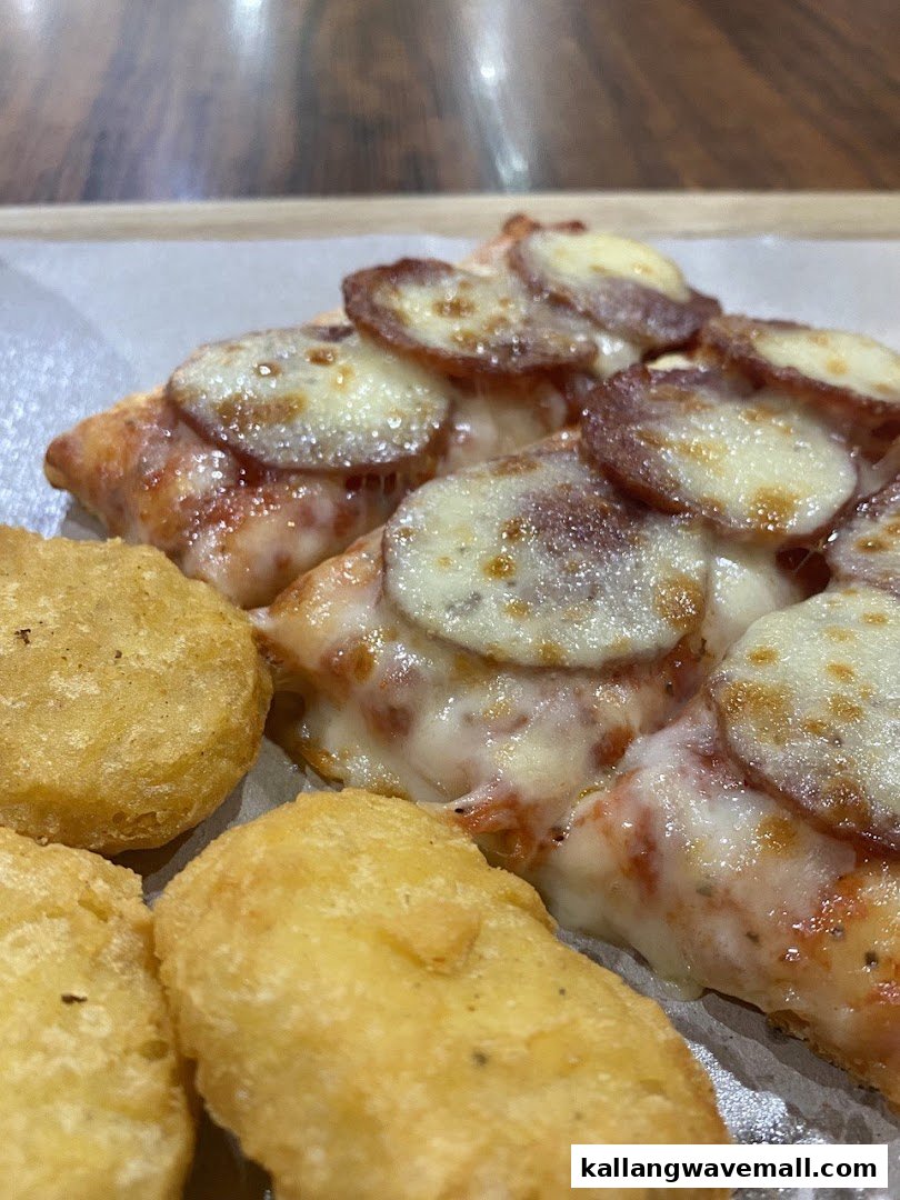 Close-up of a delicious pizza slice with pepperoni and melted cheese, alongside golden chicken nuggets.