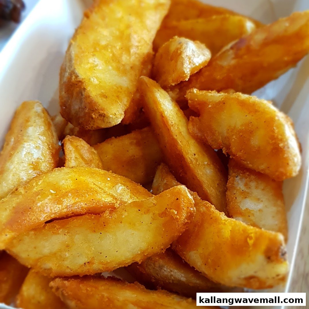 Close-up of golden, seasoned potato wedges in a white container.