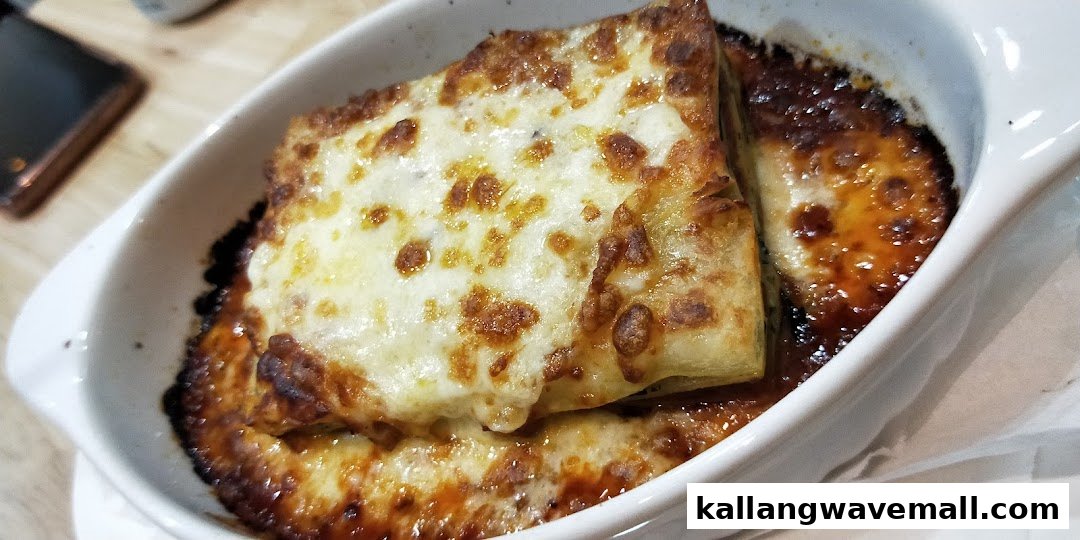 A close-up of a cheesy, baked dish, possibly lasagna, served in a white ramekin.