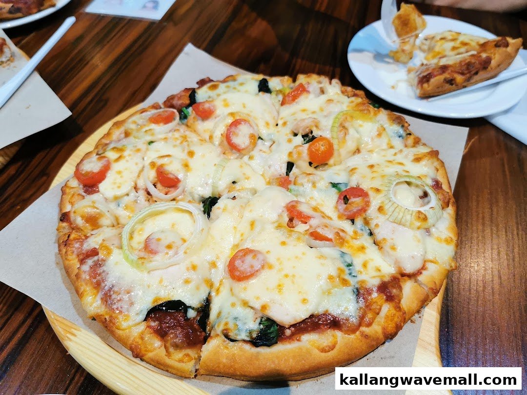 A delicious, freshly baked pizza with melted cheese, tomatoes, and onions on a wooden board.