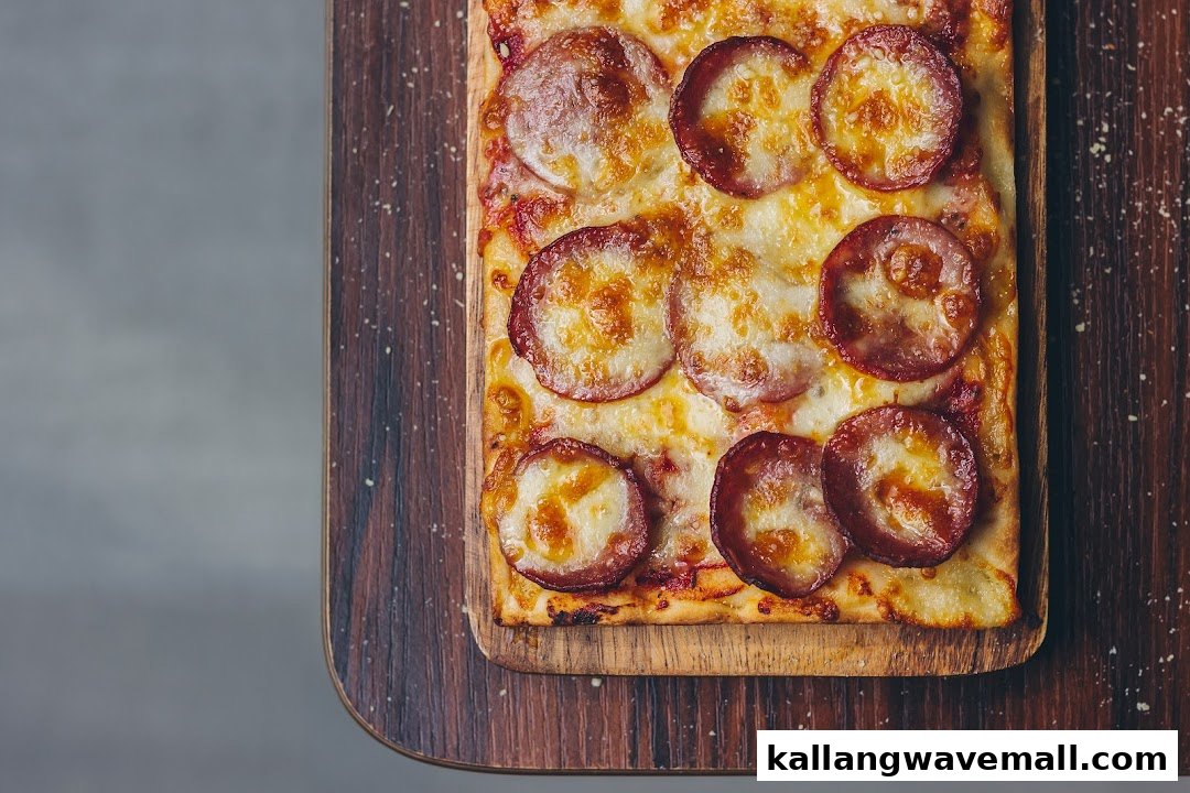 Close-up of a rectangular pepperoni pizza with melted cheese on a wooden board.