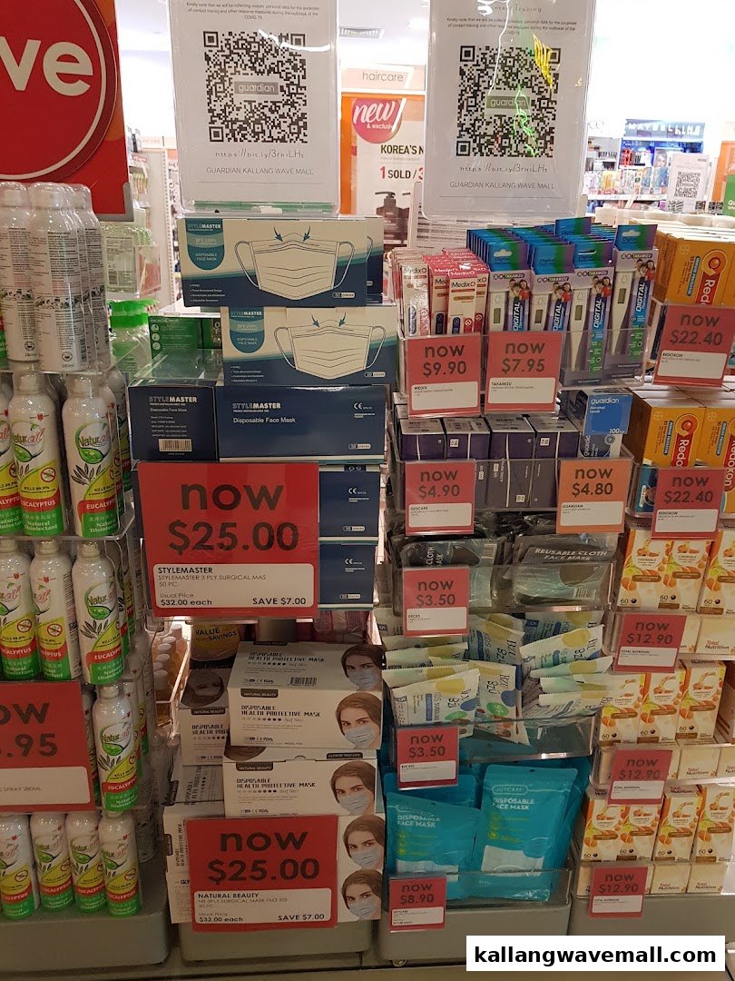 A retail display inside Guardian Health & Beauty, featuring face masks, thermometers, and other health products with promotional prices.