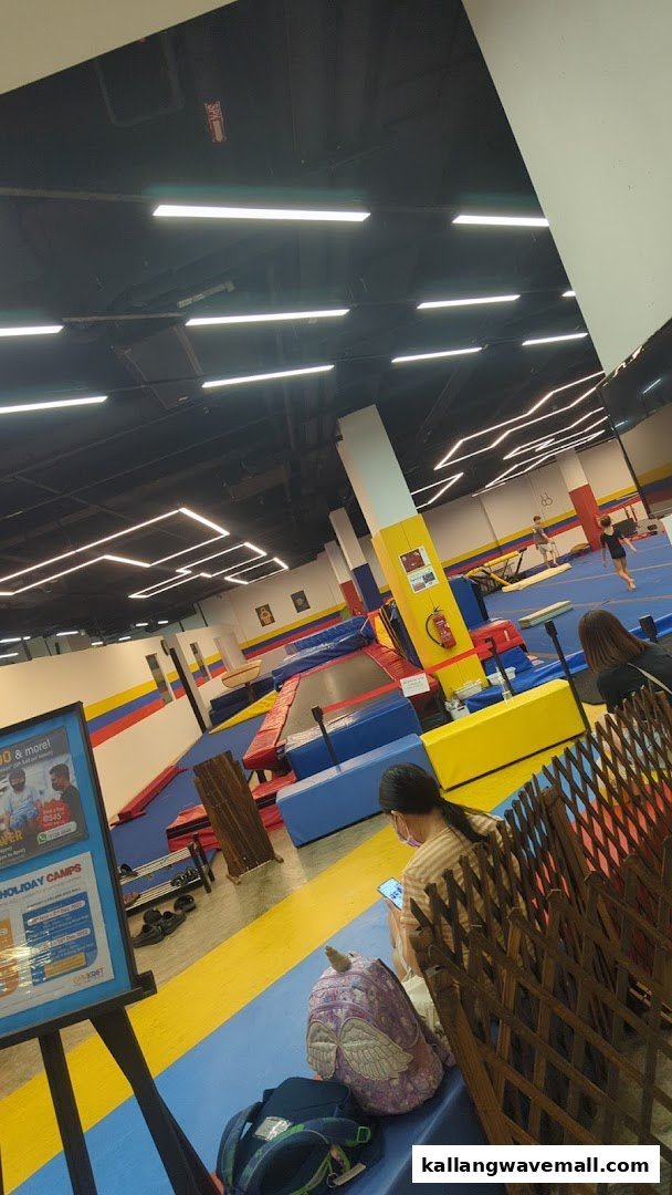 Interior view of GymKraft, a spacious gymnastics and fitness facility with various equipment and participants.