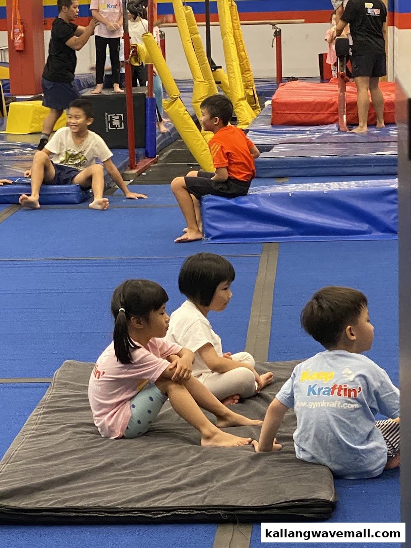 Children and adults participate in activities at a vibrant indoor gymnastics and parkour gym.
