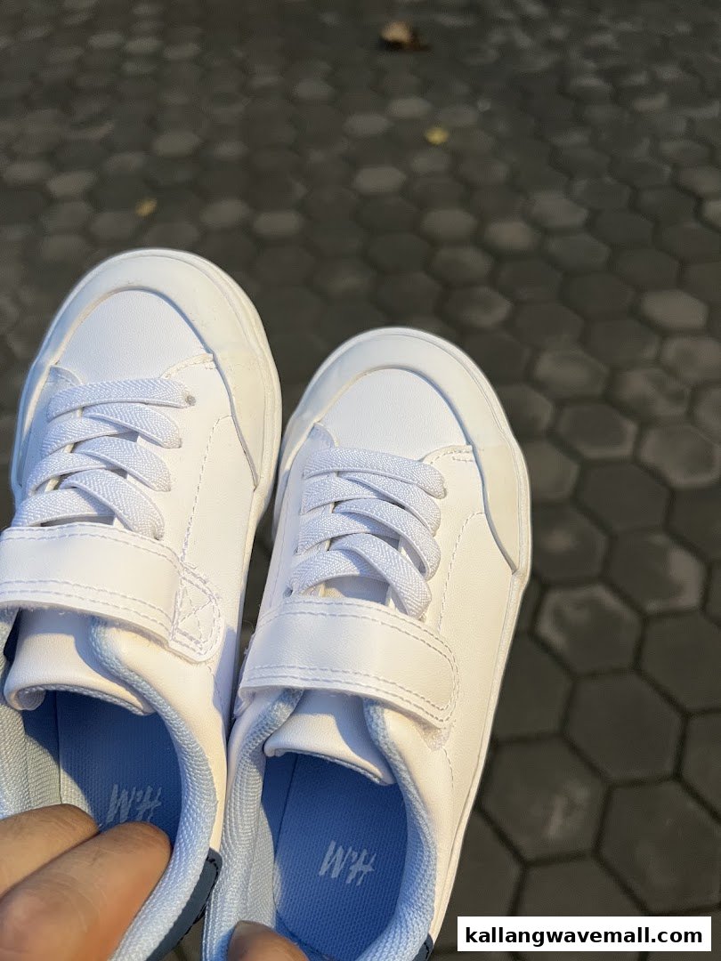 A pair of white sneakers with light blue insoles, featuring the H&M logo.