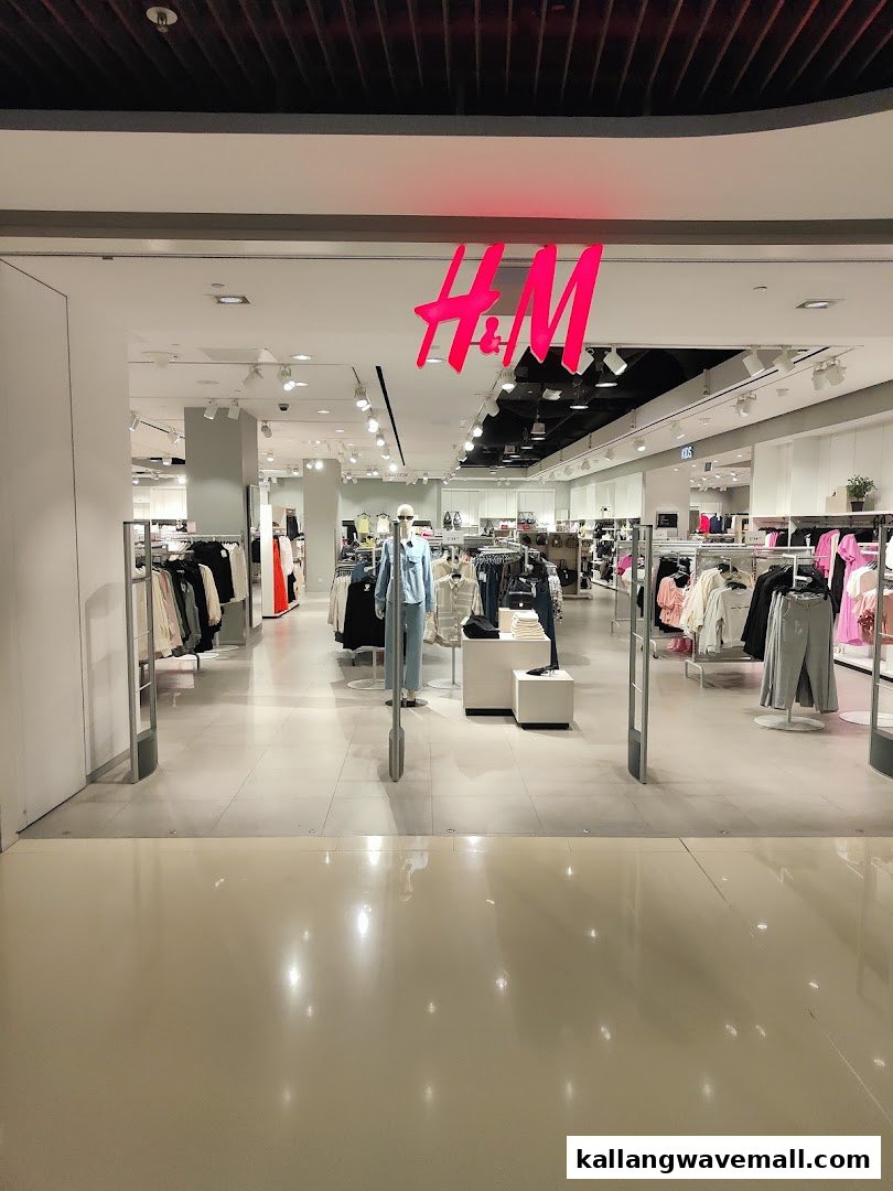 View of the H&M store entrance with its bright pink logo and interior displays.