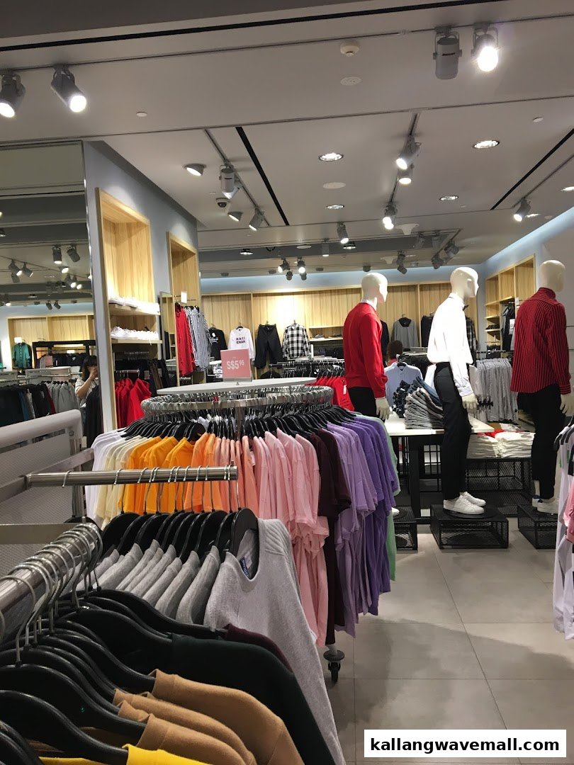 Interior view of a vibrant H&M clothing store, showcasing colorful apparel on racks and mannequins.