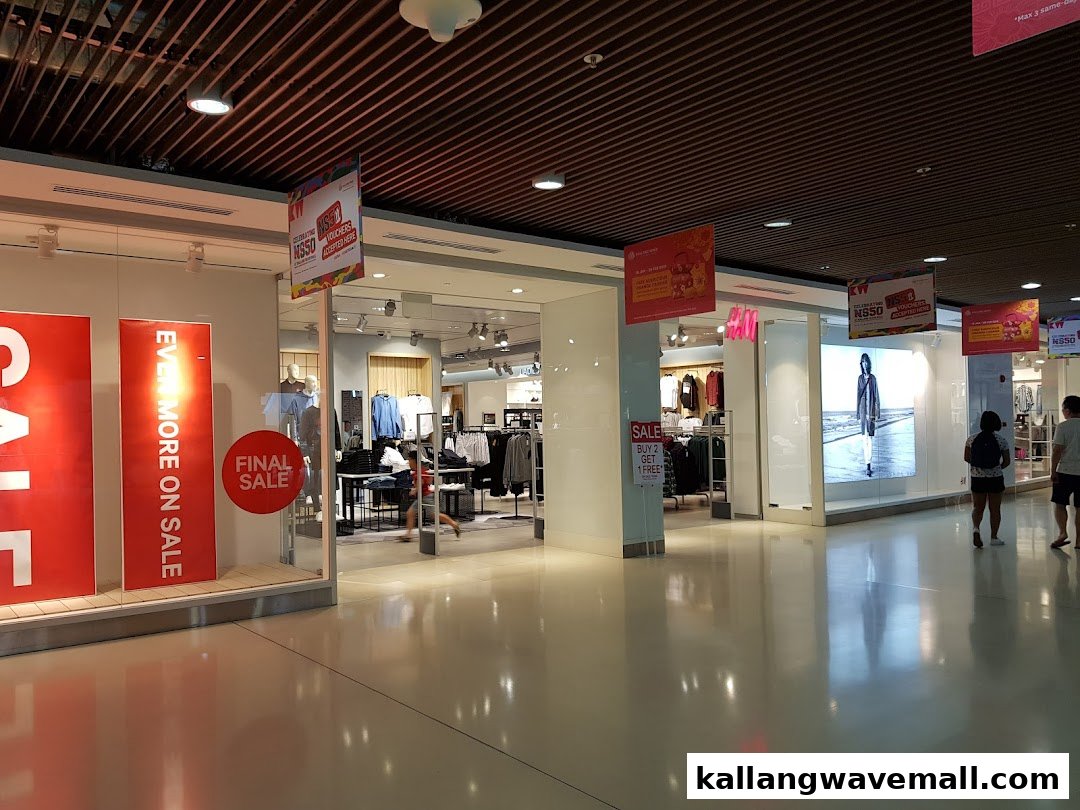 The H&M store entrance features prominent sale signs and displays, inviting shoppers inside.