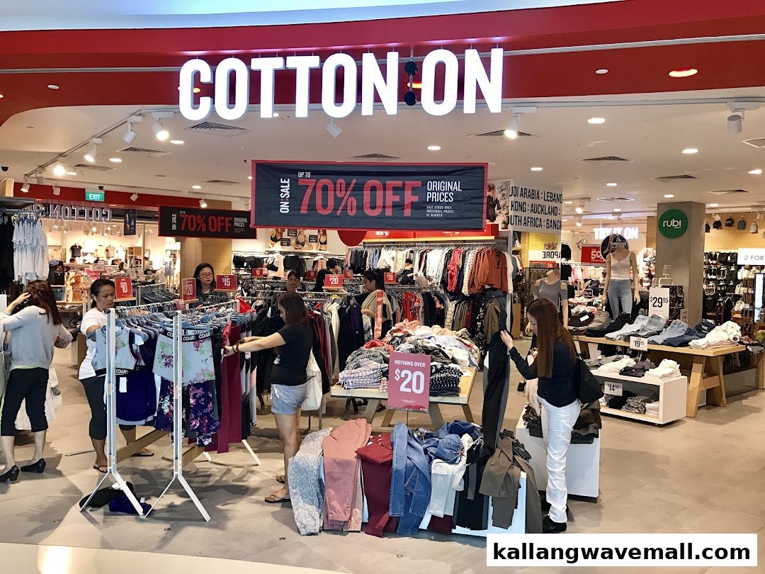 Customers browse clothing and sale items inside a Cotton On store.