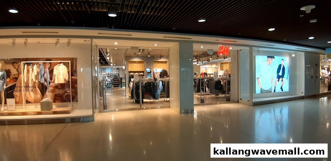 The brightly lit H&M shop front features large window displays showcasing current fashion trends and promotions.