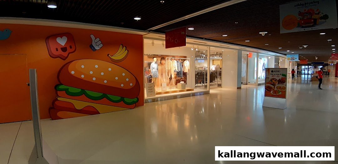 The H&M store entrance within a shopping mall, featuring window displays and a vibrant wall mural.