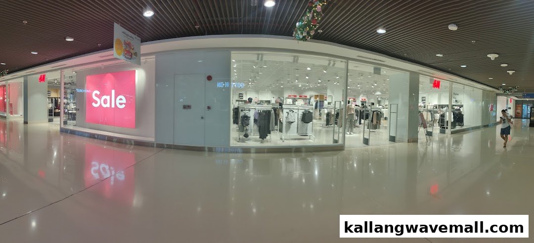 A wide view of the H&M store entrance and window displays, featuring a prominent 'Sale' sign.