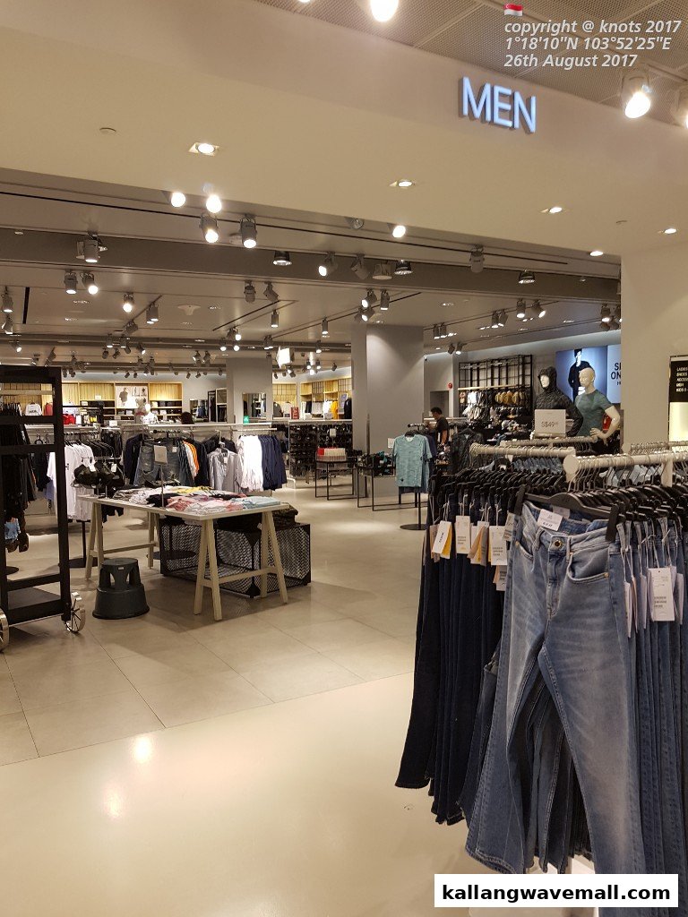 Interior view of a modern clothing store, showcasing racks of men's apparel and mannequins.