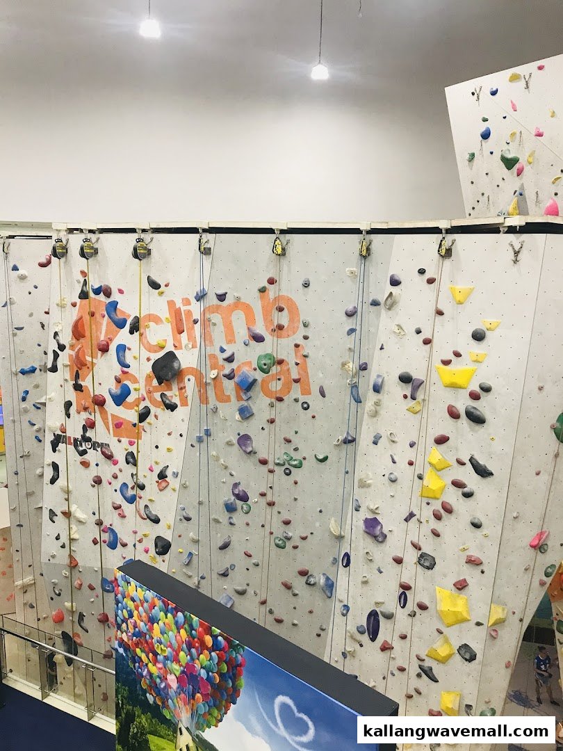 An indoor climbing gym with multiple walls covered in colorful holds and ropes.