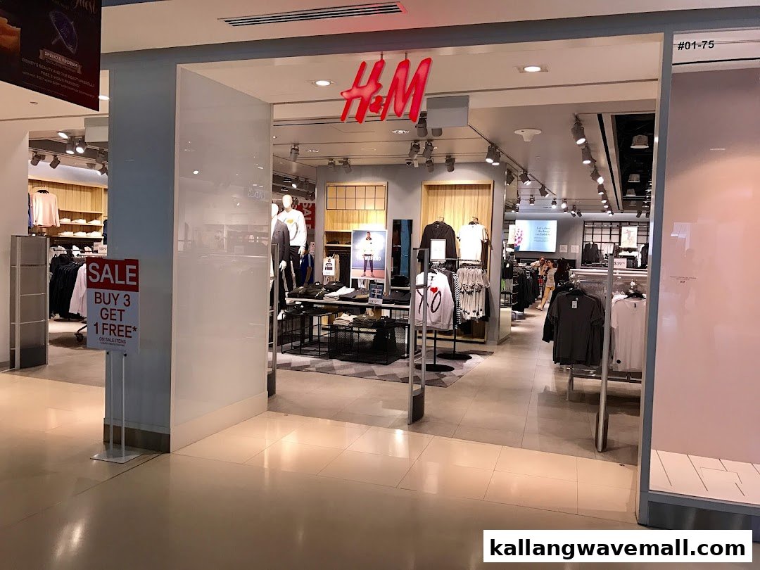 The entrance of an H&M store showcasing its bright logo and a prominent 'Buy 3 Get 1 Free' sale sign.