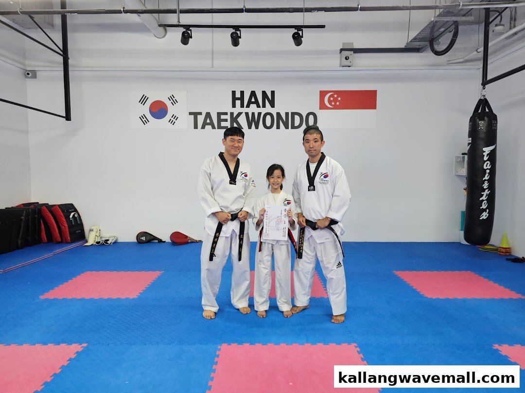 Two Taekwondo instructors and a student proudly pose in the training studio.