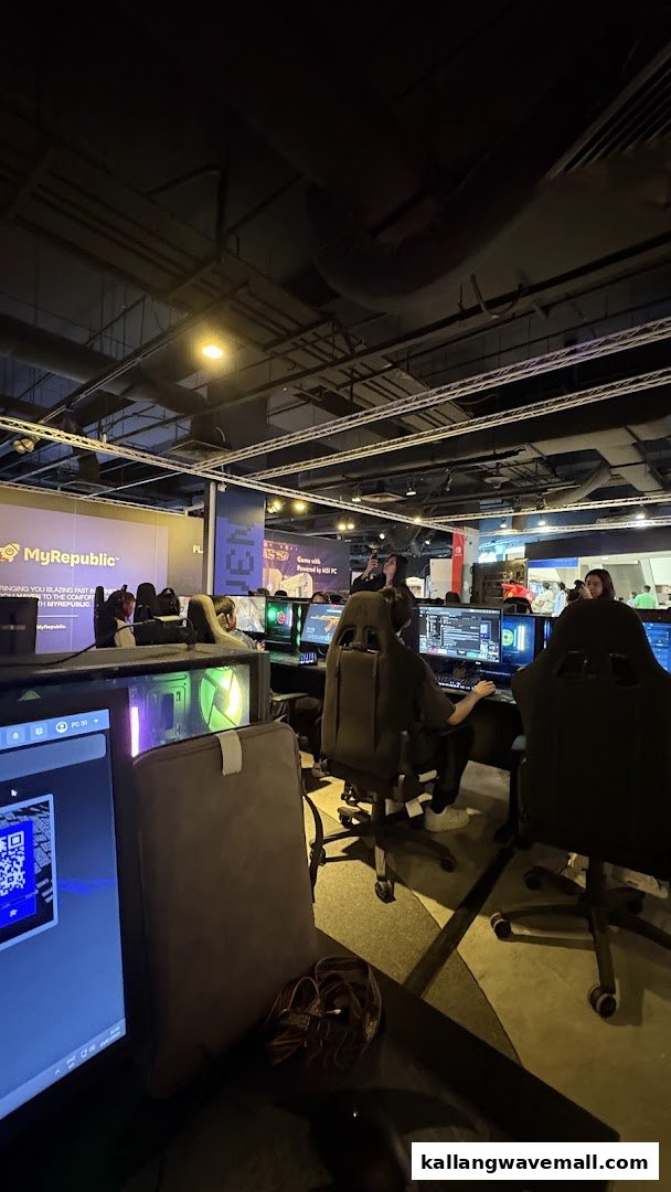 Gamers immersed in action at a modern LAN cafe with high-performance PCs and comfortable chairs.