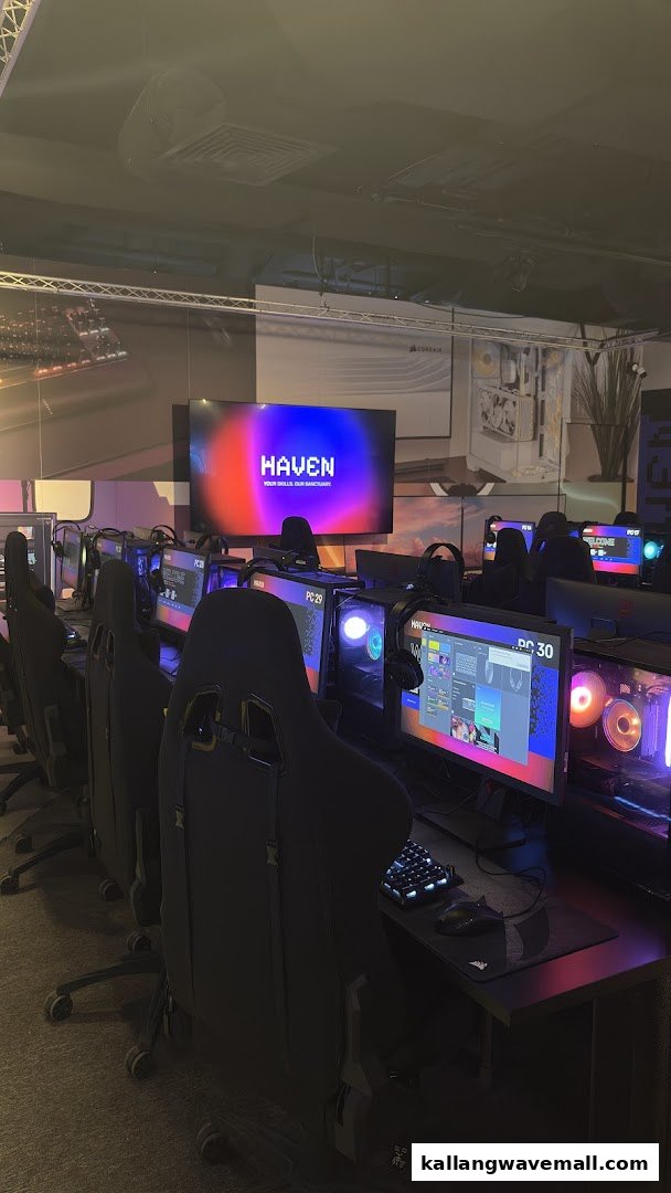 Rows of high-performance gaming PCs with ergonomic chairs in a modern esports LAN cafe.