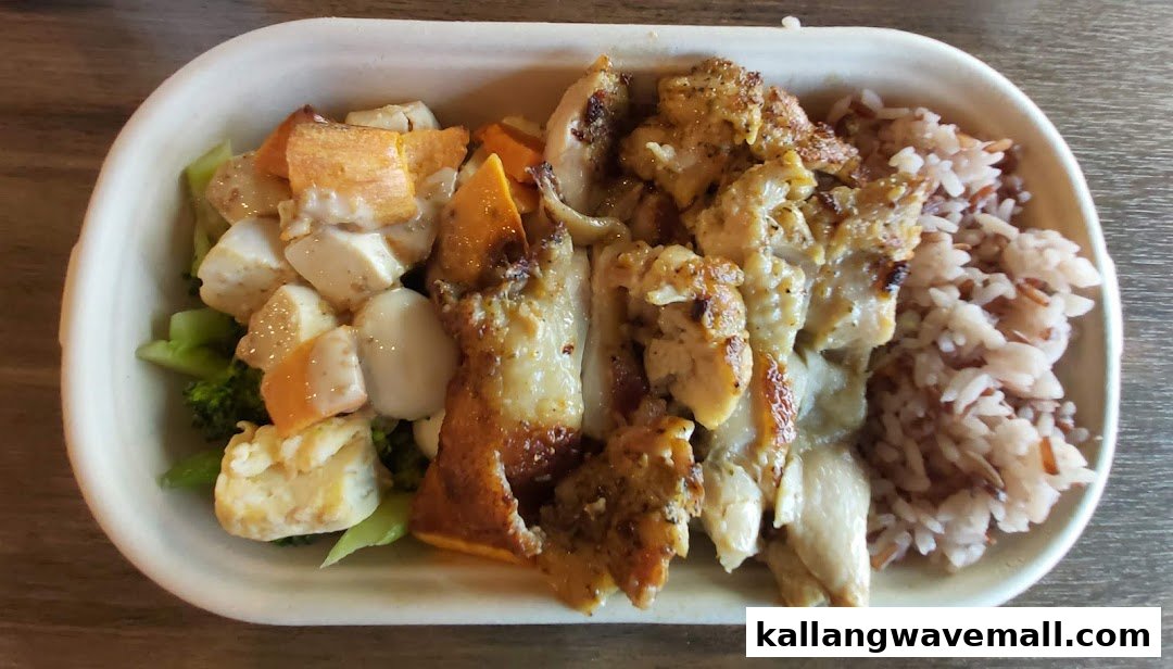 A healthy meal bowl featuring grilled chicken, mixed vegetables, tofu, and brown rice.