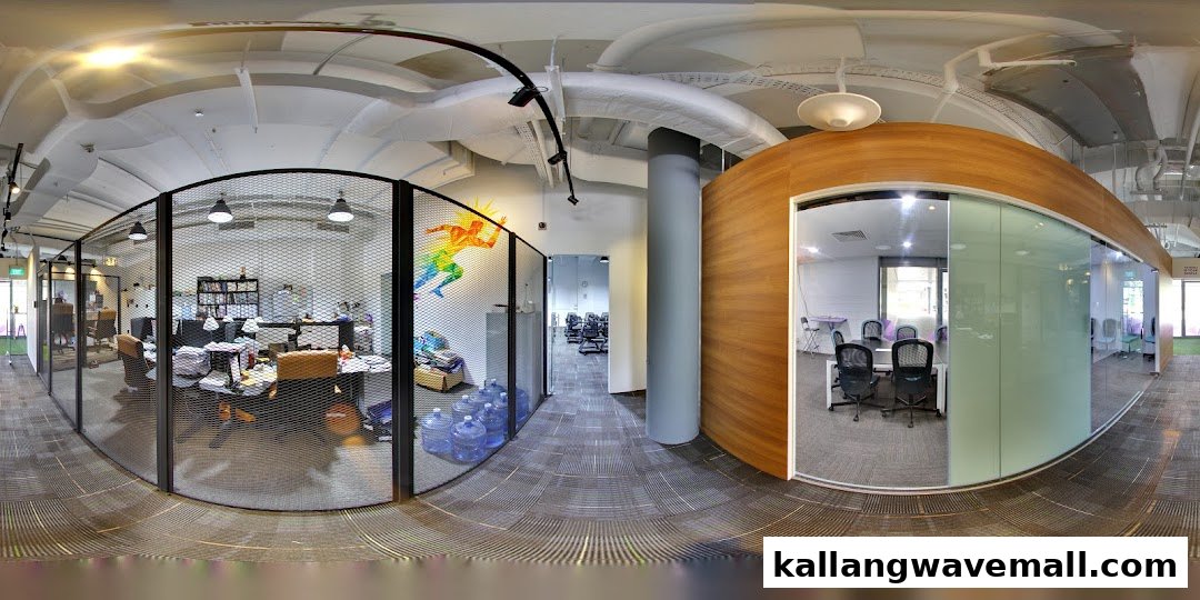 A panoramic view of International Sports Academy's modern office space with open workstations and a meeting room.