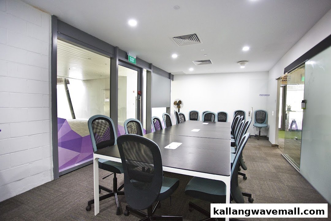 A modern, well-lit meeting or classroom space with a large table and ergonomic chairs.