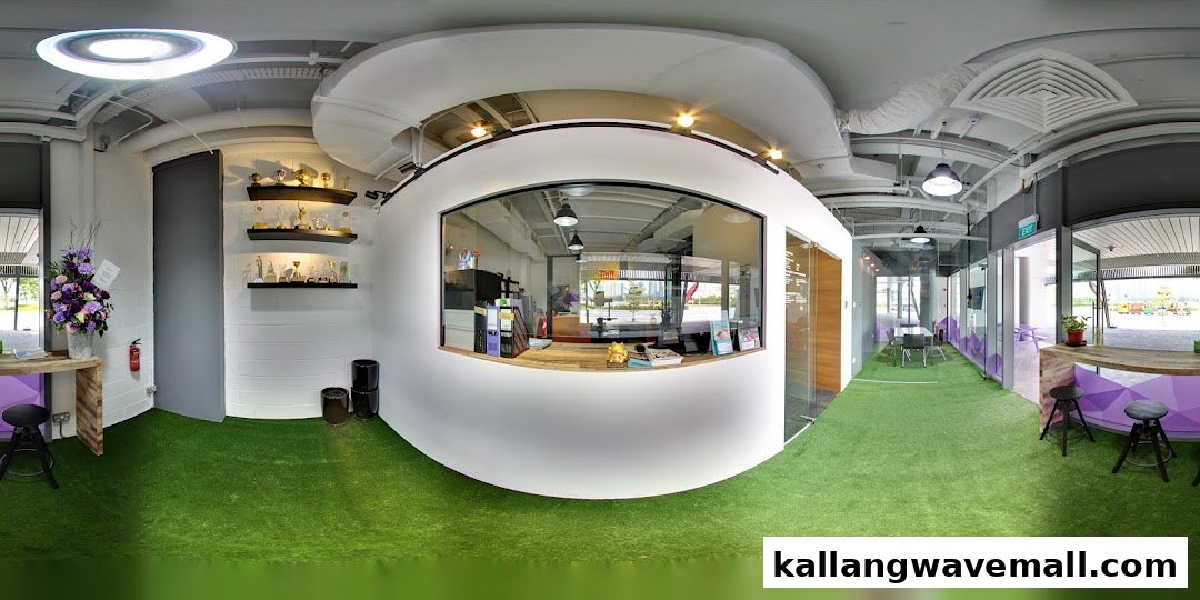 A modern interior view of International Sports Academy ISA, featuring a reception, artificial turf, and trophy display.