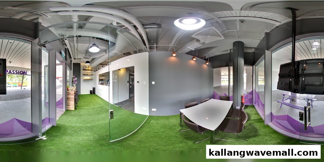 A modern interior of a sports academy featuring artificial grass flooring, a meeting area, and glass partitions.