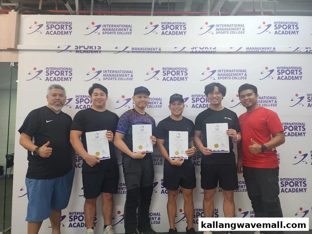 Six individuals, some holding certificates, pose in front of an International Sports Academy banner.